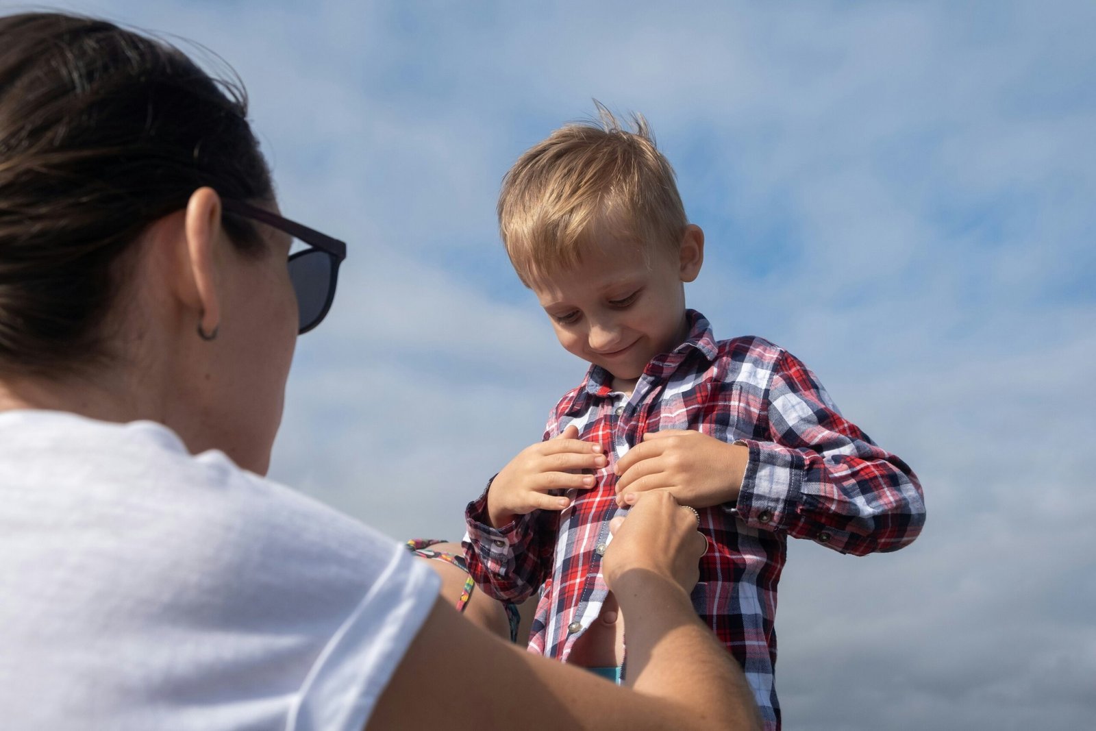 A woman is holding a young boy on a boat